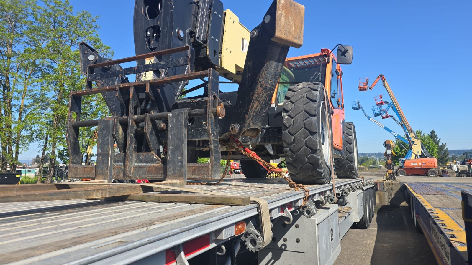 Heavy equipment on open-deck trailer