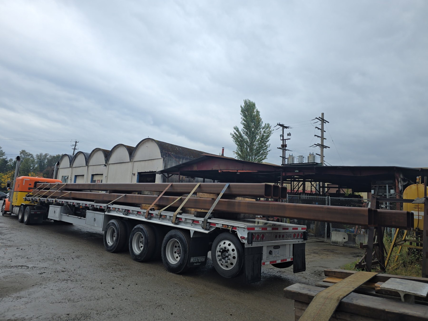 Long structural steel secured on an Oracle Carriers flatbed trailer